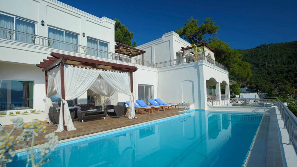Private villa terrace with pergola, custom outdoor furniture and pool at Rixos Premium Bodrum, part of Cocoplum's hotel refurbishment portfolio.