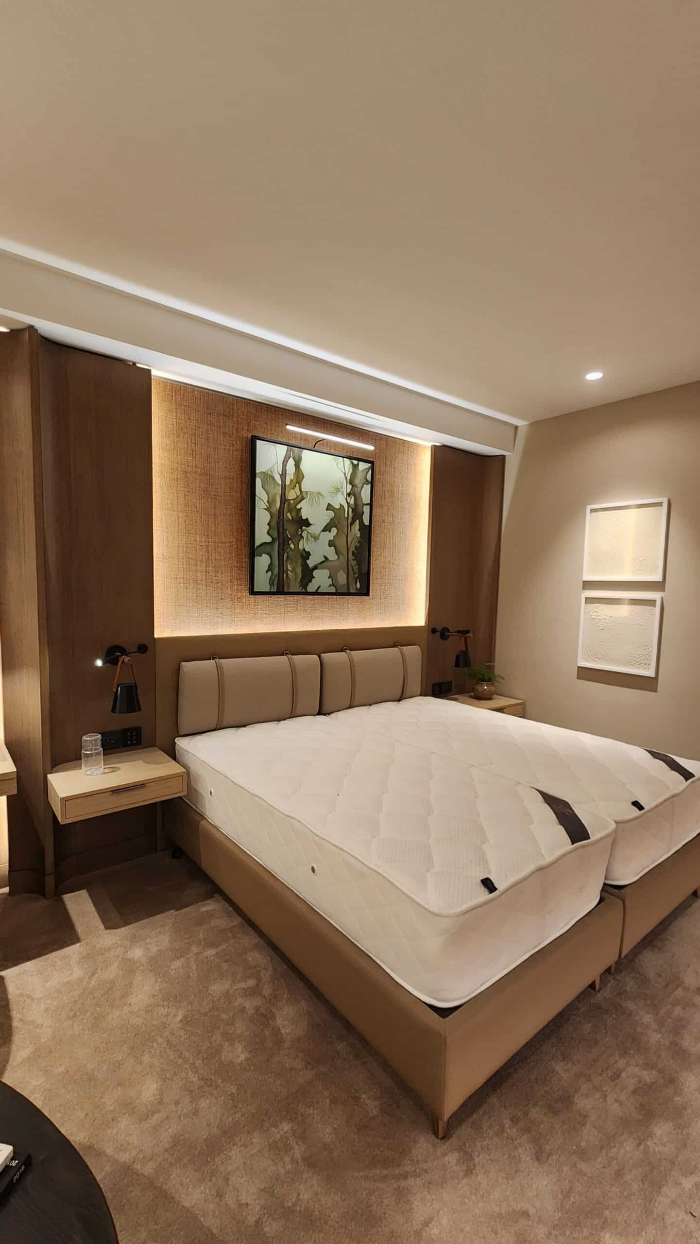 Full-scale prototype hotel guest room with upholstered headboard and timber joinery, built before production as part of turnkey hotel delivery