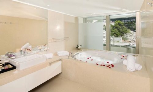 Luxury wellness interior designed by Ozge Fettahlioglu – biophilic hotel suite with timber, natural stone and greenery, by Cocoplum Wellness Design.